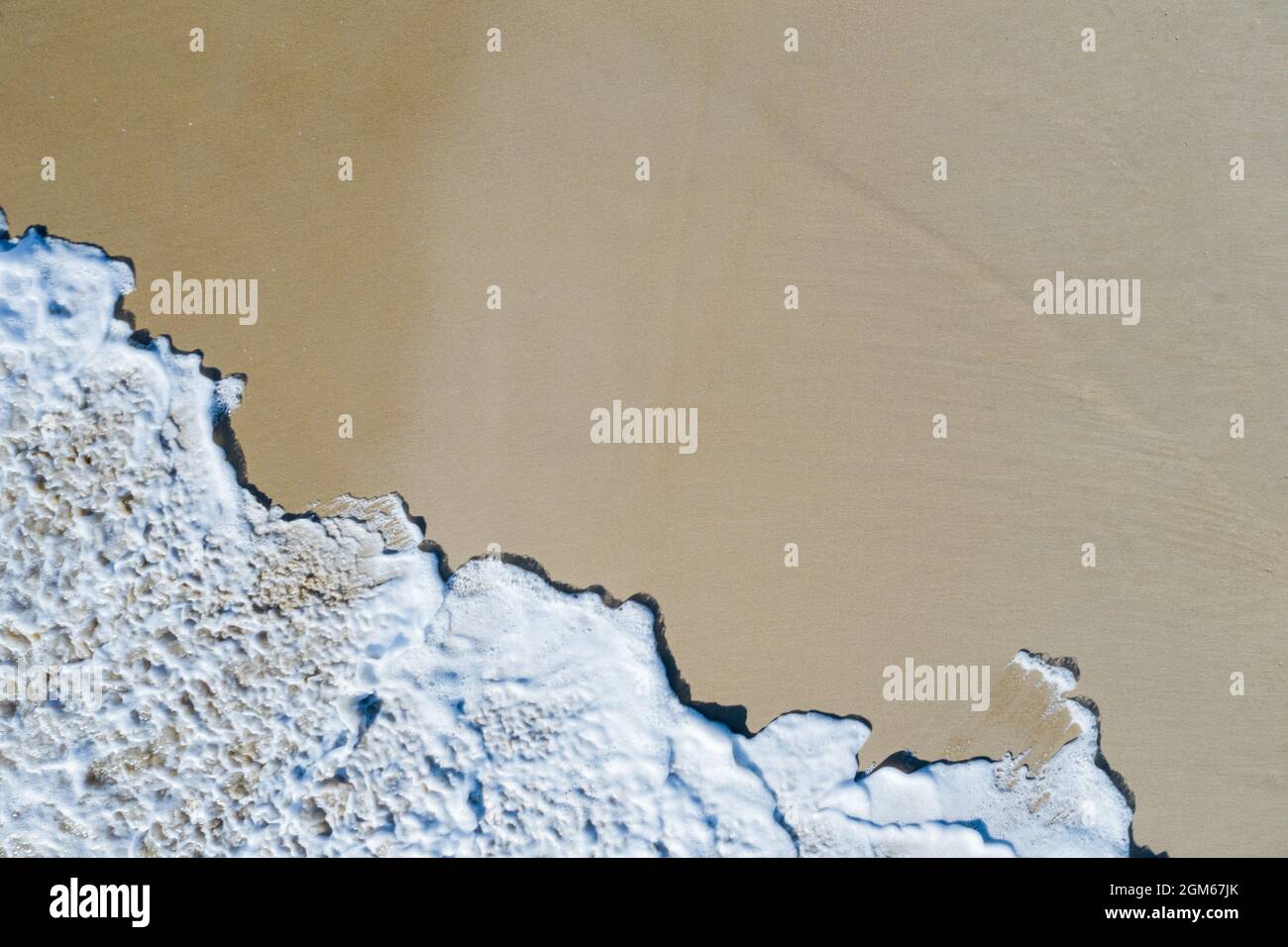 Vista dall'alto verso il basso dell'onda che si infrange sulla spiaggia Foto Stock