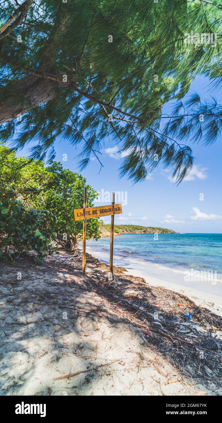 Cartello di avvertimento sul bordo della spiaggia contro il cielo blu Foto Stock