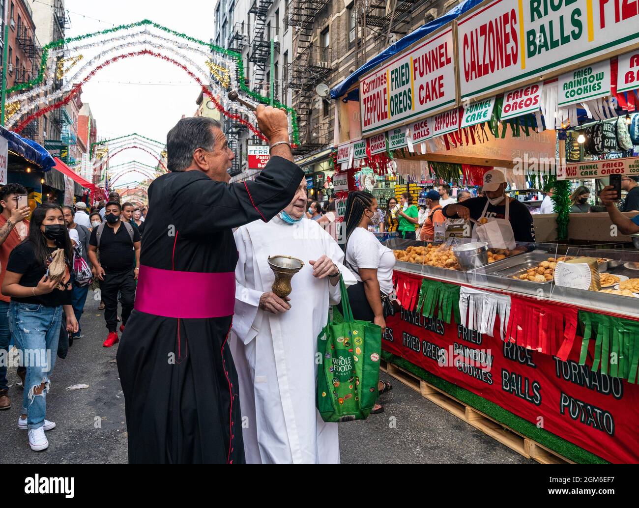 Atmosfera durante la Festa di San Gennaro 2021 a Little Italy a New York il 16 settembre 2021. Si tratta di una festa annuale che si svolge nel quartiere di Little Italy per celebrare la vita di San Gennaro di Napoli, Vescovo di Benevento, Italia e martirizzato nel 305 d.C. L'evento è stato annullato nel 2020 a causa di una pandemia e tornò in pieno svolgimento quest'anno. La strada di Mulberry e l'area circostante erano piene di venditori ambulanti che offivano piatti tradizionali italiani e un afflusso di altre cucine come quella latina e cinese. Il primo giorno di festeggiamenti Monsignor David Cassato ha eseguito il suo Foto Stock