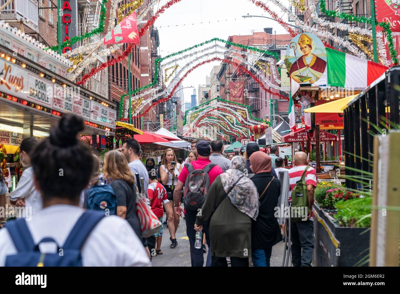 Atmosfera durante la Festa di San Gennaro 2021 a Little Italy a New York il 16 settembre 2021. Si tratta di una festa annuale che si svolge nel quartiere di Little Italy per celebrare la vita di San Gennaro di Napoli, Vescovo di Benevento, Italia e martirizzato nel 305 d.C. L'evento è stato annullato nel 2020 a causa di una pandemia e tornò in pieno svolgimento quest'anno. La strada di Mulberry e l'area circostante erano piene di venditori ambulanti che offivano piatti tradizionali italiani e un afflusso di altre cucine come quella latina e cinese. Il primo giorno di festeggiamenti Monsignor David Cassato ha eseguito il suo Foto Stock