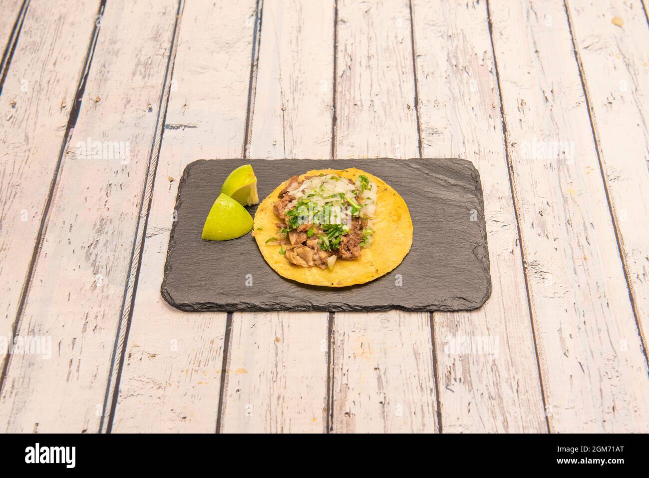 Taco suadero messicano con tortilla di mais giallo, manzo stufato, coriandolo, cipolla tritata e lime Foto Stock