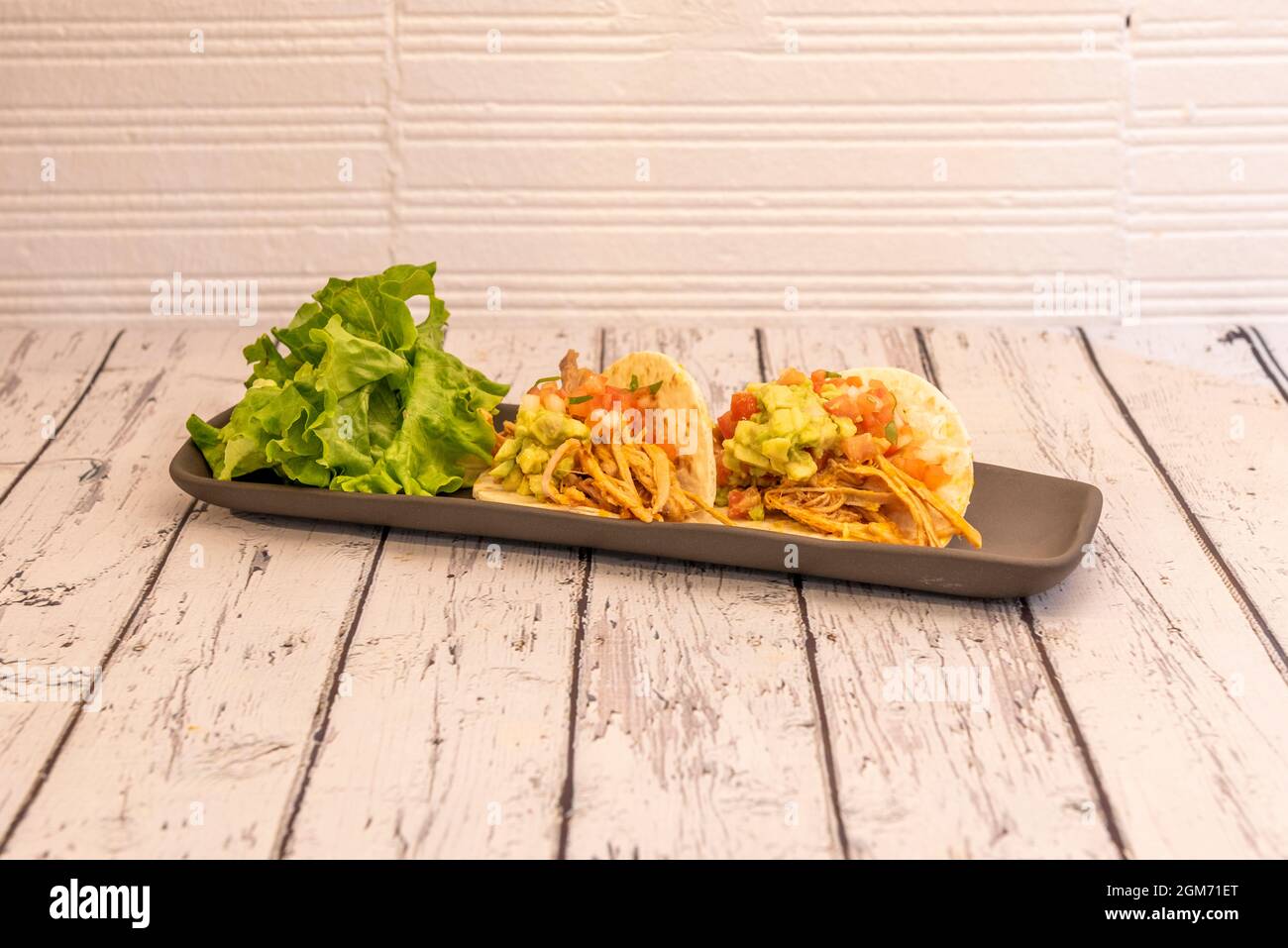 tingo di pollo messicano con guacamole e Pico de gallo su sfondo bianco Foto Stock tingo di pollo messicano con guacamole e Pico de gallo su sfondo bianco Foto Stock