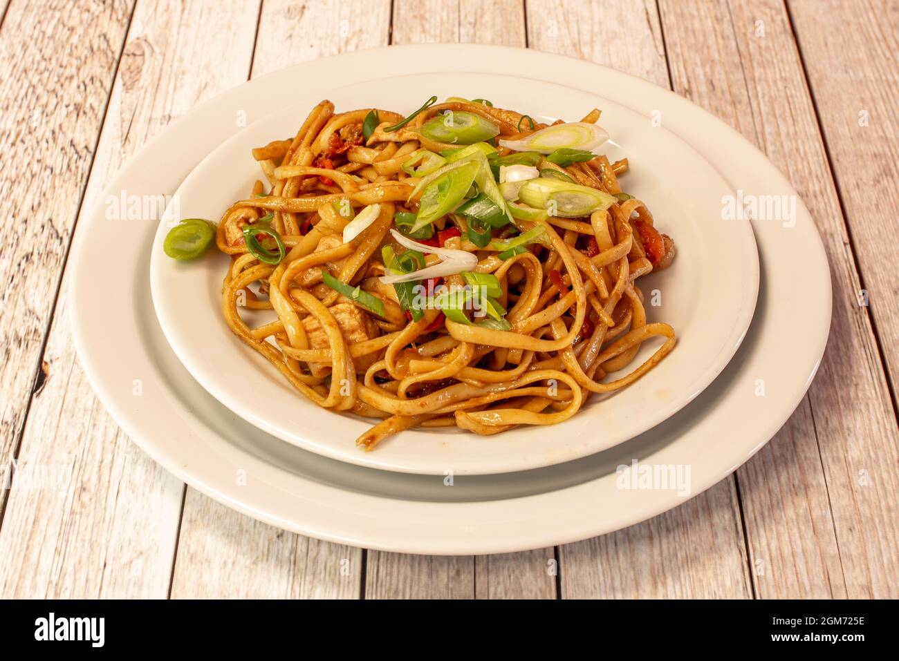 Tagliatelle saltate con verdure e pollo con erba cipollina tritata con salsa di soia cucinata da uno chef cinese Foto Stock