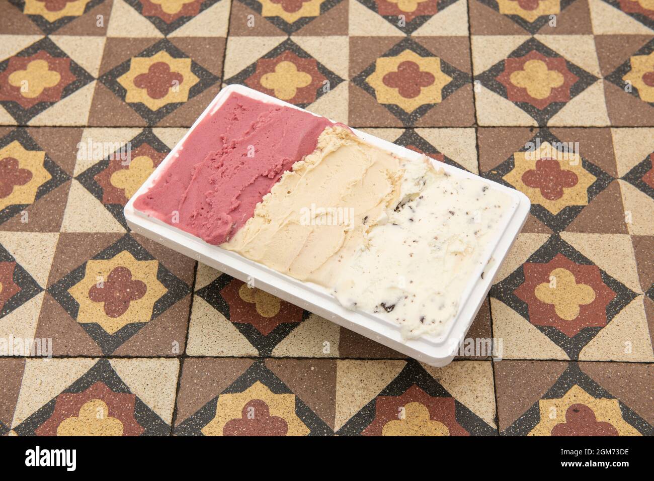 Deliziosa vasca da mezzo litro per gelato a tre gusti su un tavolo idraulico per piastrelle Foto Stock