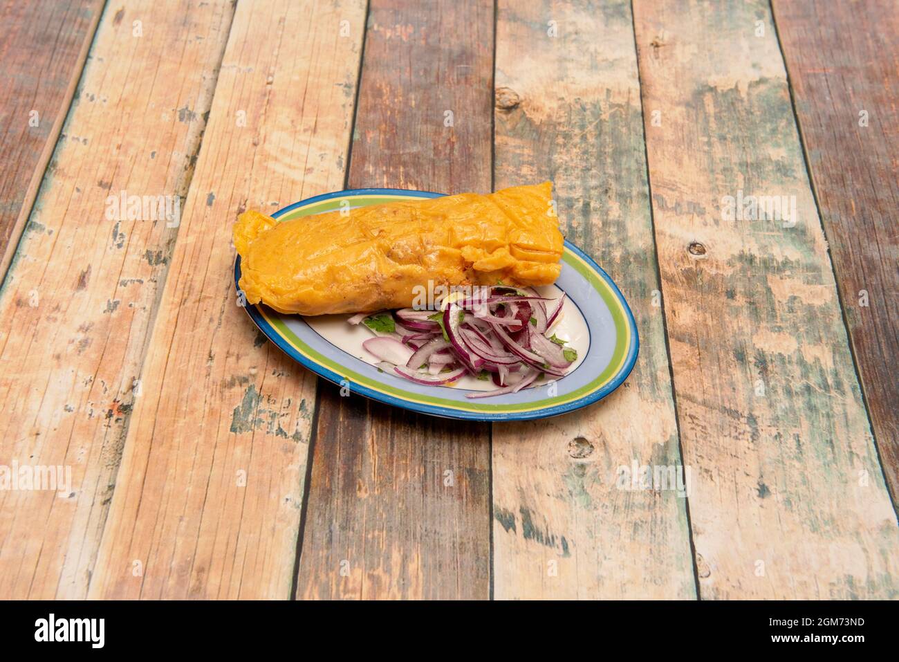 Vassoio molto colorato con tamale ripieno di carne di pollo con ricetta messicana con cipolla viola e coriandolo Foto Stock