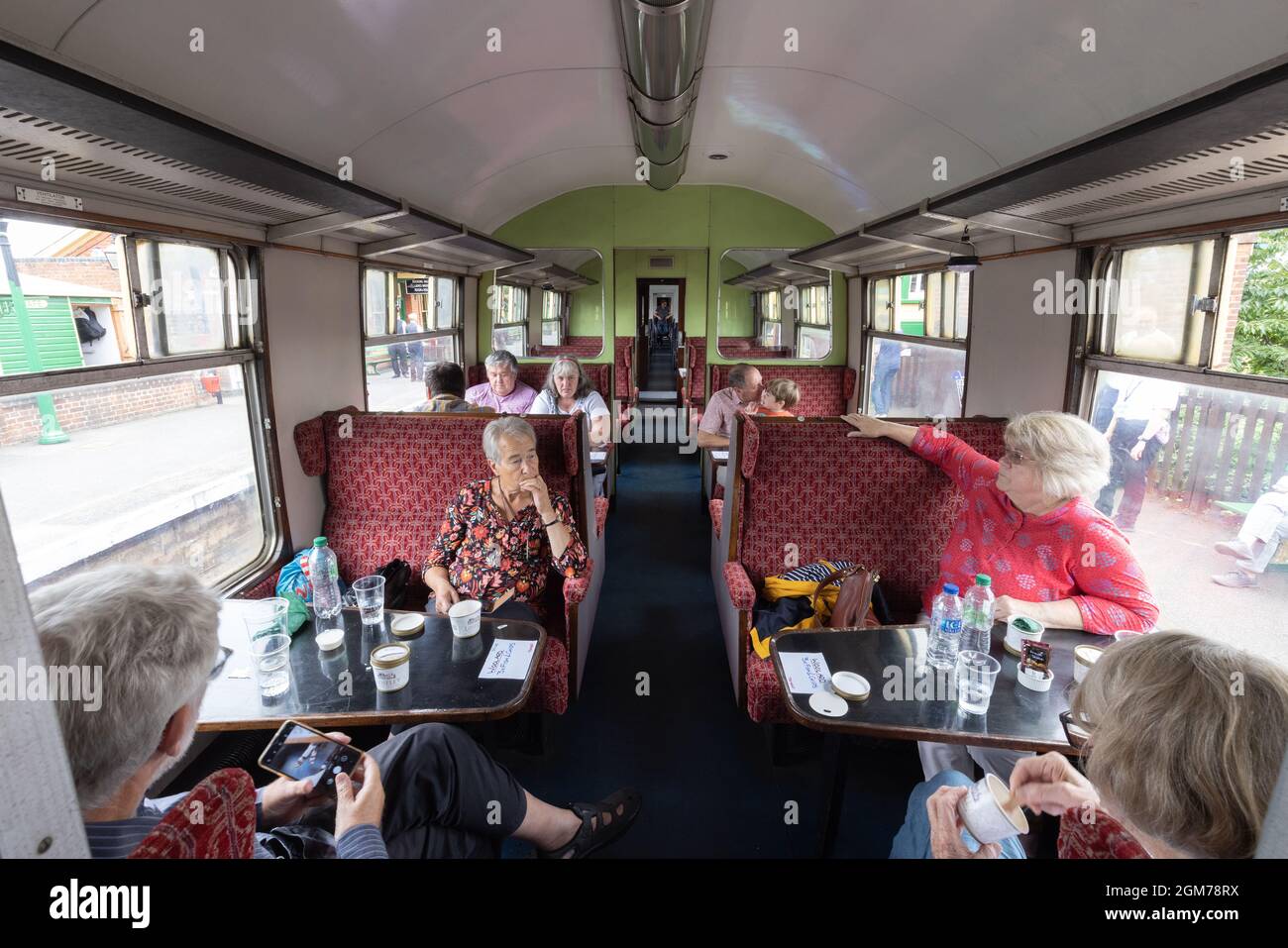 Epping Ongar Railway, una ferrovia del patrimonio che gestisce il treno Epping Fryer; persone che mangiano e bevono in una carrozza d'epoca su un treno a vapore, Essex UK Foto Stock