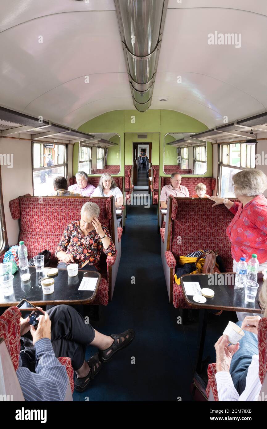 Epping Ongar Railway, una ferrovia del patrimonio che gestisce il treno Epping Fryer; persone che mangiano e bevono in una carrozza d'epoca su un treno a vapore, Essex UK Foto Stock