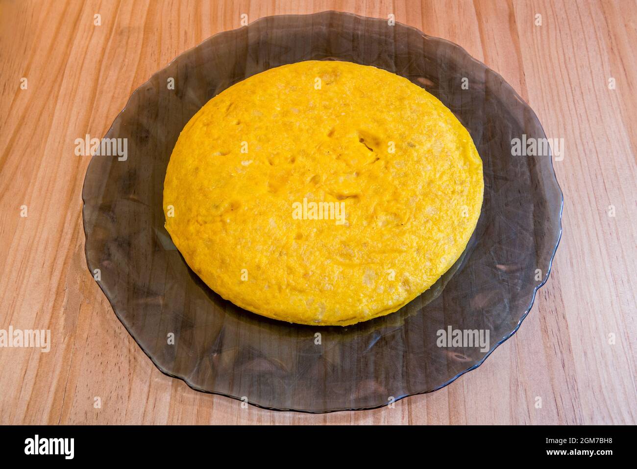 Frittata di patate spagnola su un piatto di vetro grigio pronto per essere servito in un tapas bar Foto Stock