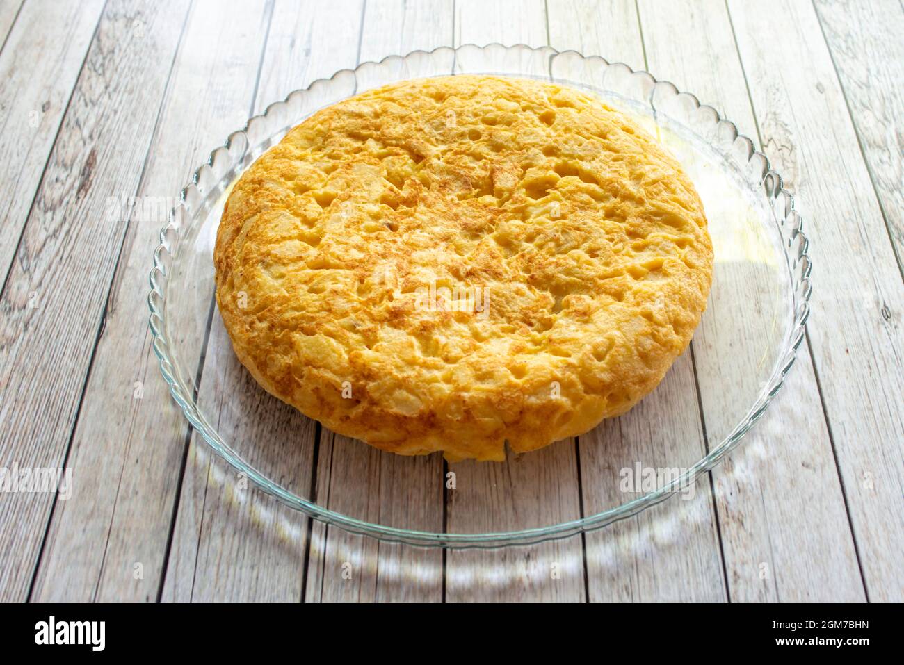 Ottima frittata di patate spessa con cipolla su un vassoio trasparente di cristallo servito in un tapas bar spagnolo Foto Stock