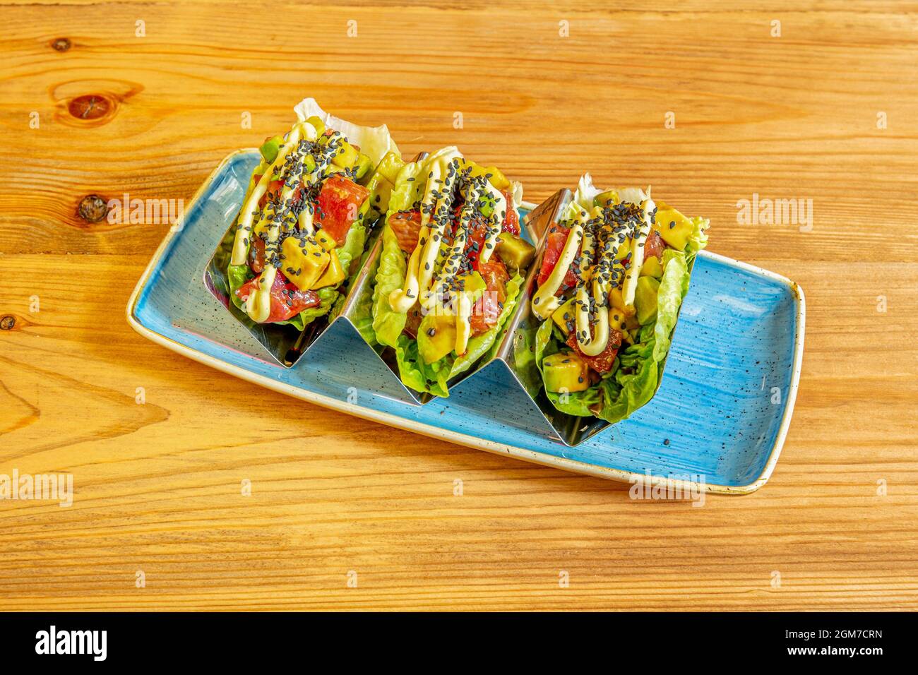 Taco di tonno con avocado e semi di papavero arrotolati con foglie di germoglio Foto Stock