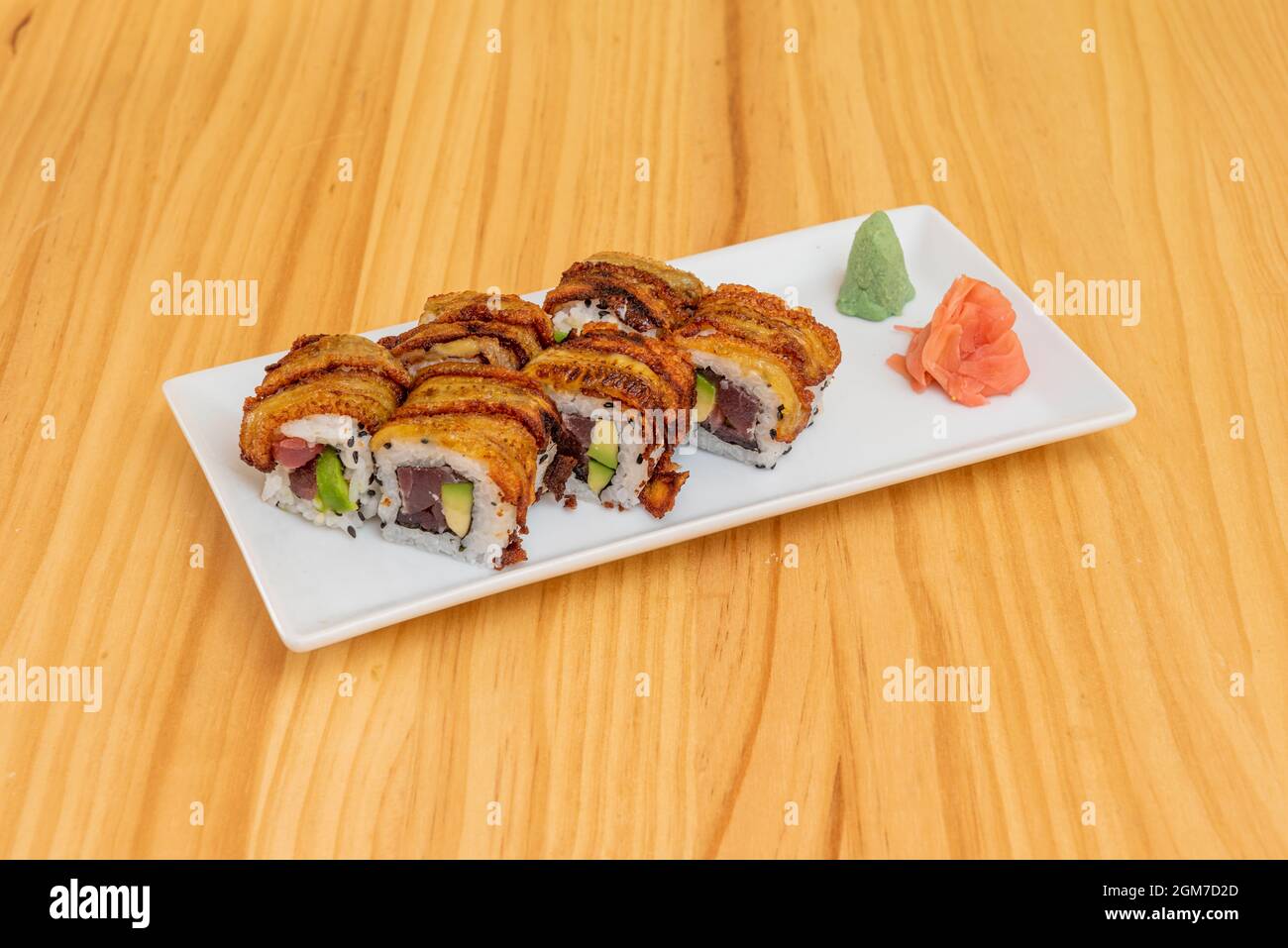 Rotolo giapponese di Uramaki con banana matura fritta e ripieno di tonno rosso con avocado, wasabi e zenzero Foto Stock