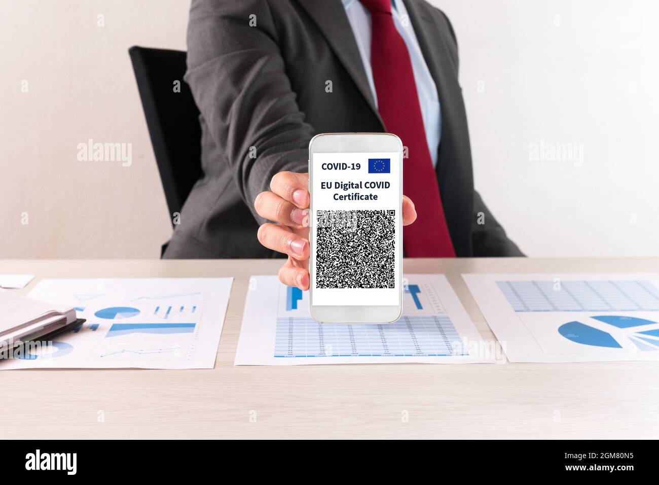 Uomo d'affari che mostra il suo certificato di vaccino covid europeo, chiamato anche Green Pass Foto Stock