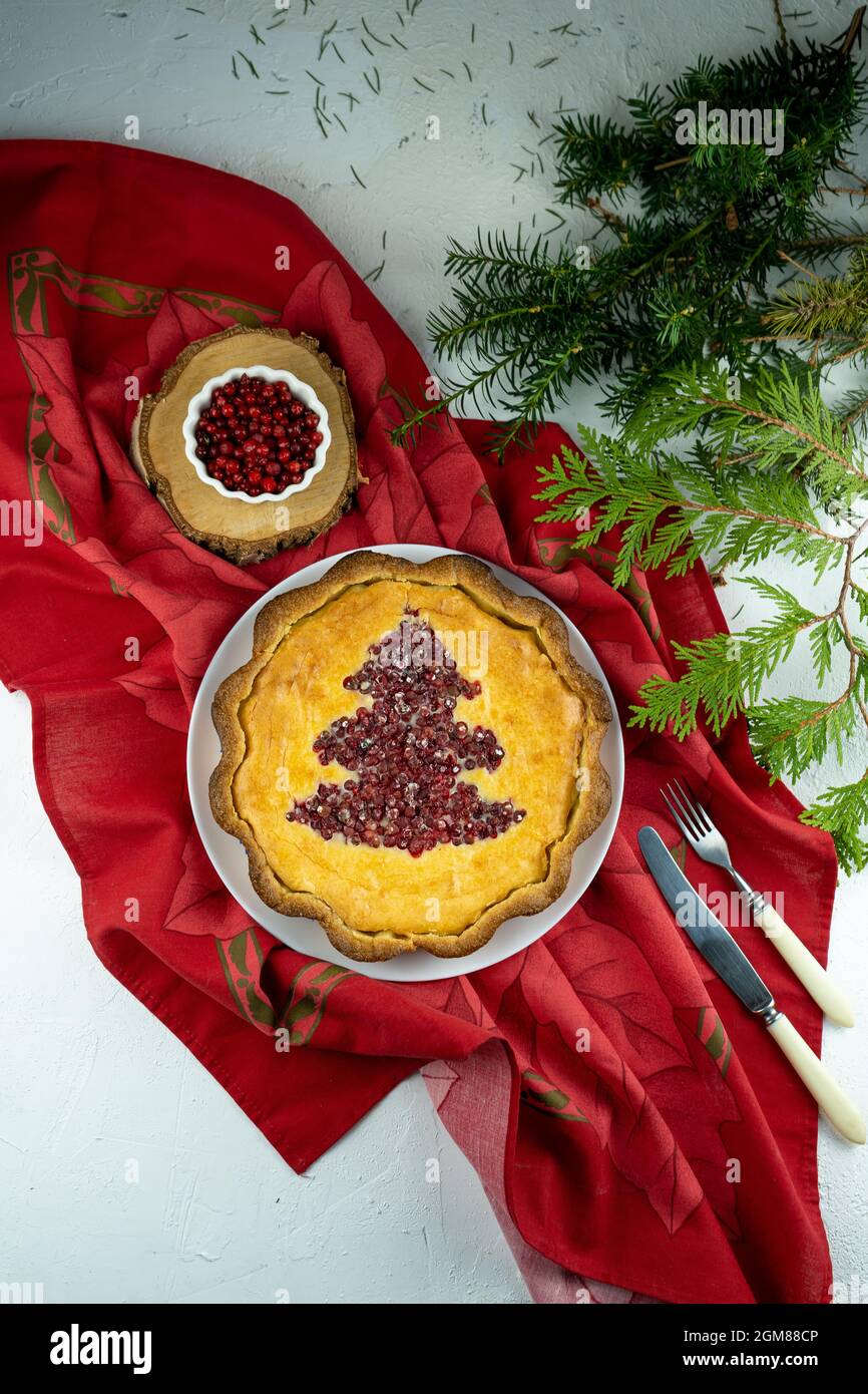 Cheesecake. Aprire la torta rotonda con mirtilli e mirtilli rossi con l'albero di Natale. Torta dolce fatta in casa con ripieno di frutti di bosco. Cibo festivo per dessert Foto Stock