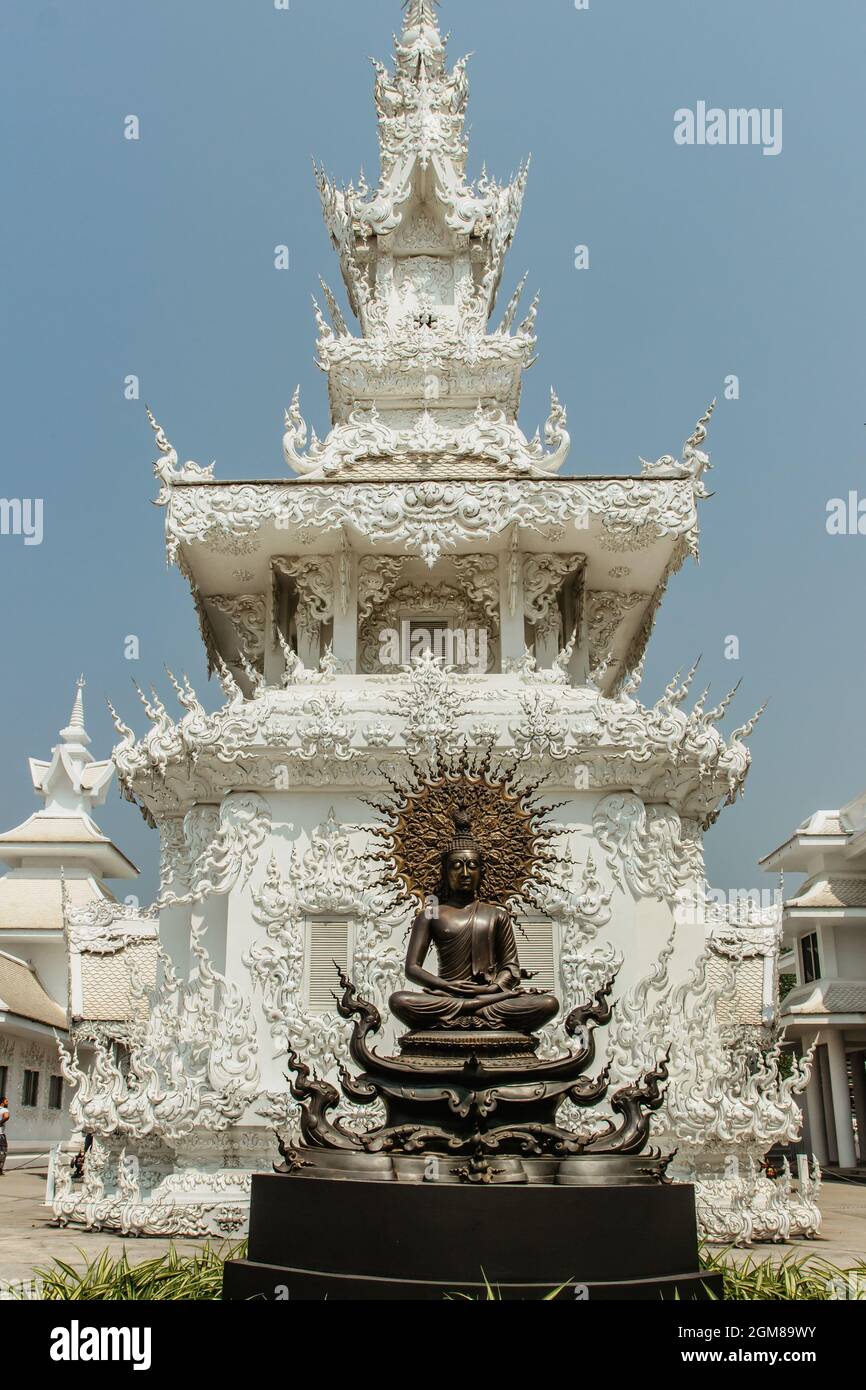 Chiang Rai, Thailandia - 16 febbraio 2020. Statua e palazzo al Tempio Bianco Buddhista Tailandese Wat Rong Khun nel nord della Thailandia. Attrazione turistica asiatica. Foto Stock