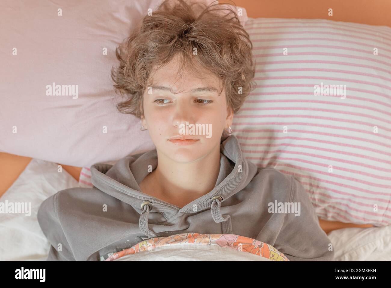 Teen girl sdraiato nel suo letto depresso Foto Stock