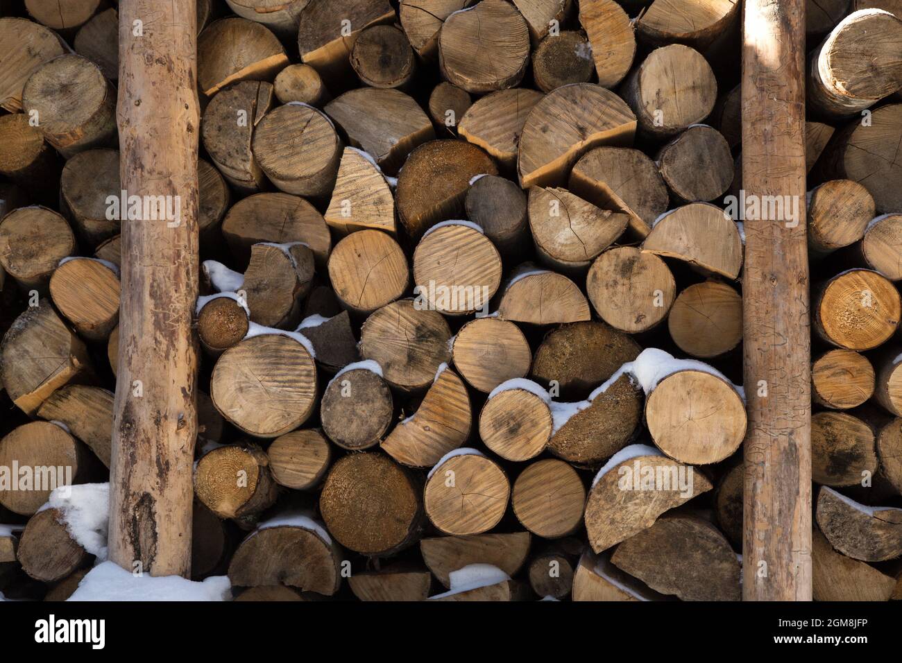 Lotti dei ceppi accatastati nella scatola di legno-bruciante. Sfondo da materiali naturali Foto Stock