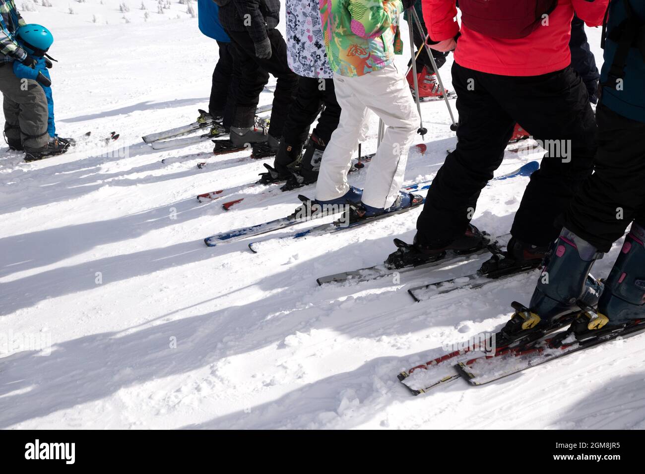 gruppo di sciatori irriconoscibili in fila prima dell'inizio della discesa dalla pista nevosa. Briefing sulla sicurezza, scuola di sci. Hobby invernale, outd Foto Stock