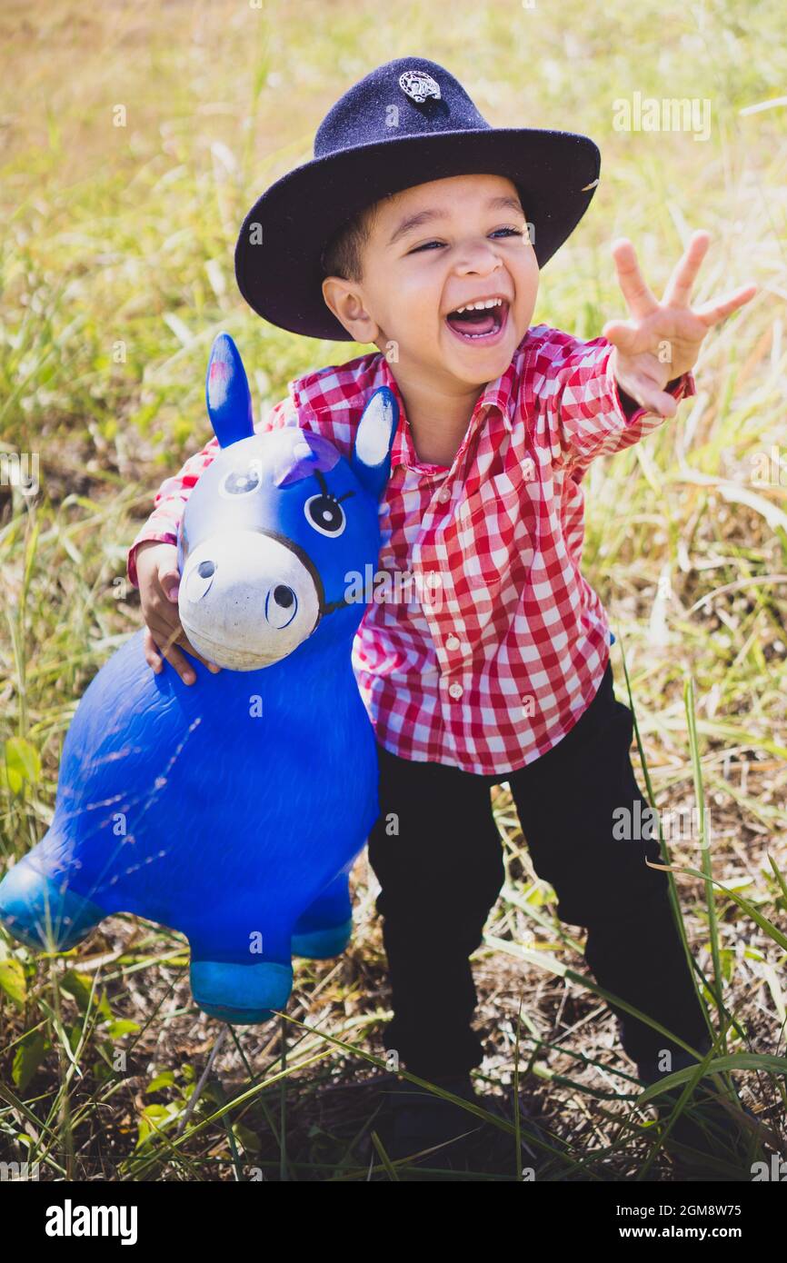 Ragazzo bianco vestito da cowboy, giocando nei boschi con il suo cavallo  giocattolo. Ritratto per bambini per giorno, moda per bambini, moda per  paese Foto stock - Alamy