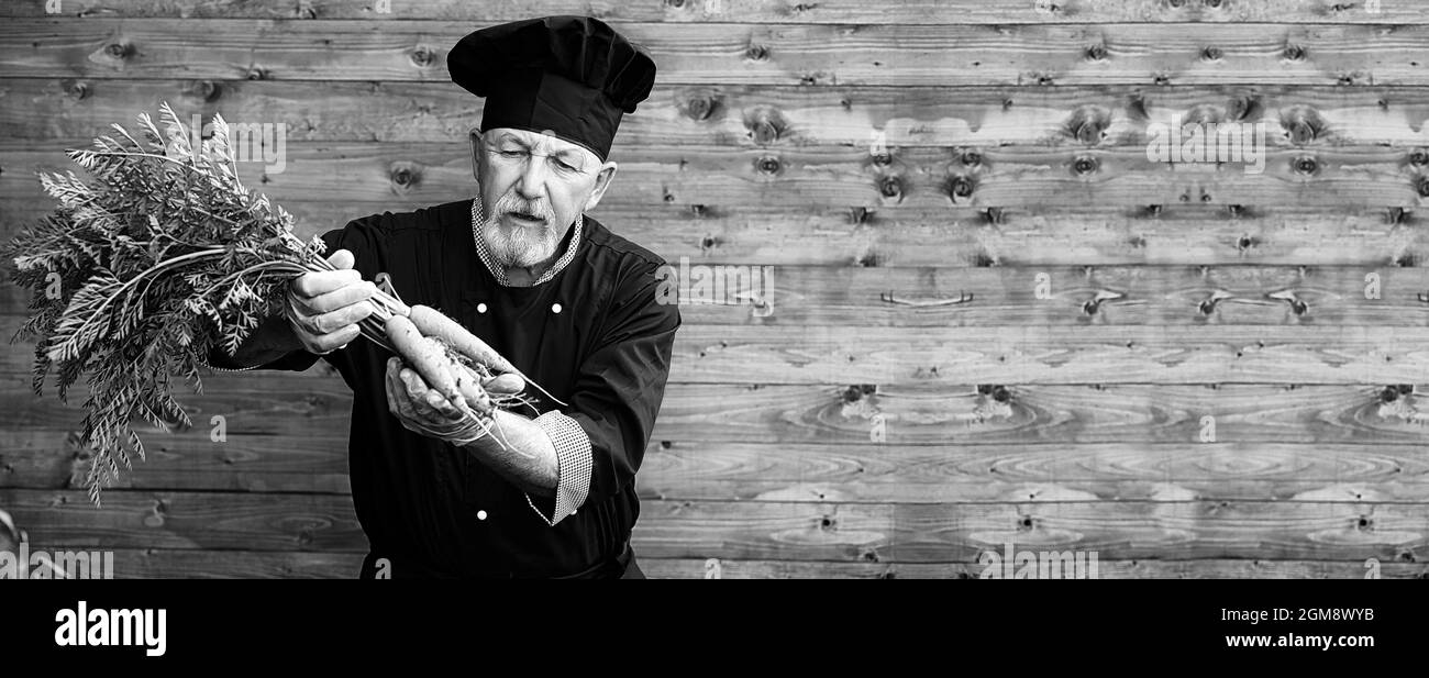 Coltivatore in uniforme con verdure fresche su un bacground di legno Foto Stock