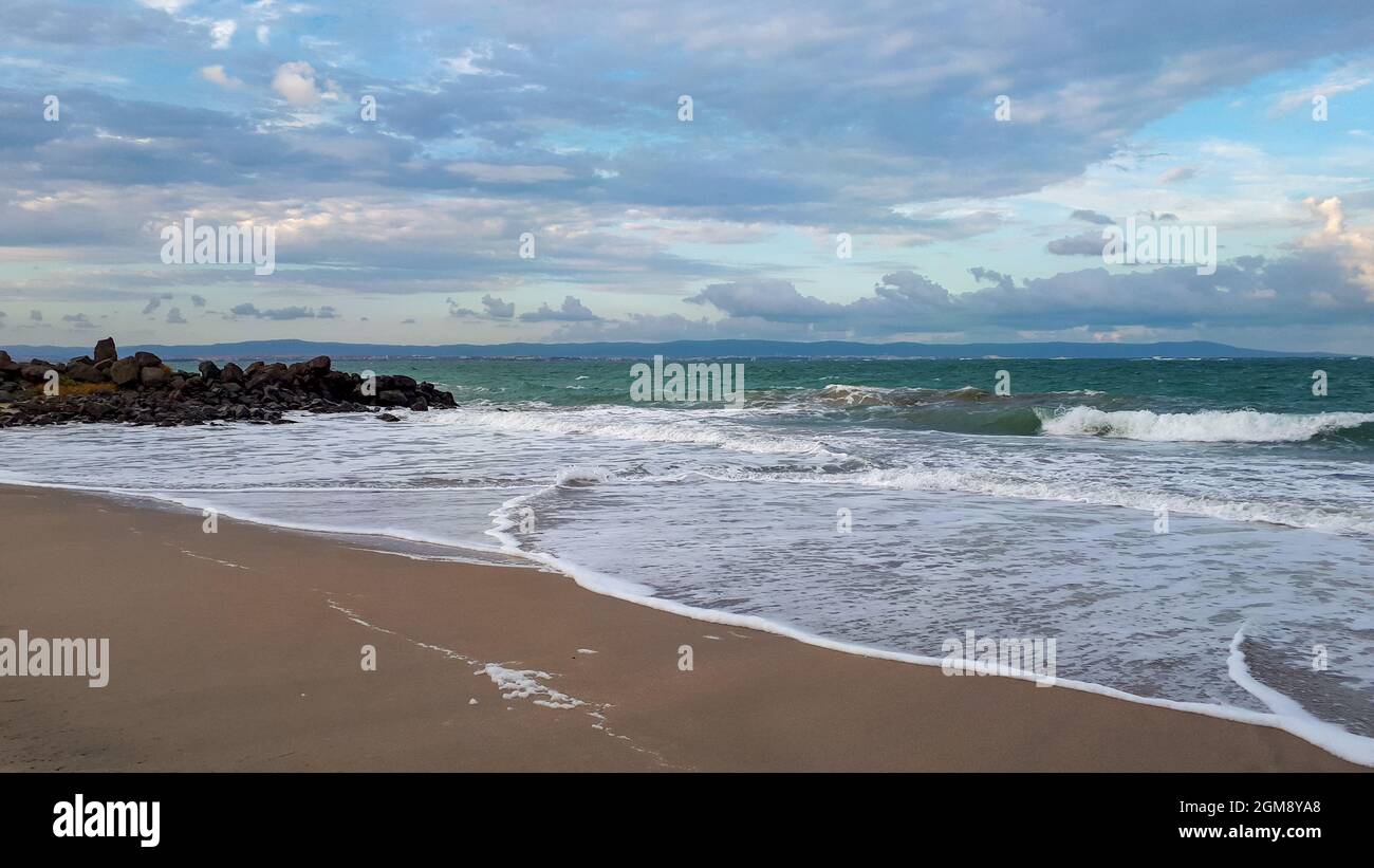 Spiaggia di sabbia al Mar Nero contro il cielo nuvoloso a Pomorie, Burgas Bay, Bulgaria al mattino. Foto Stock