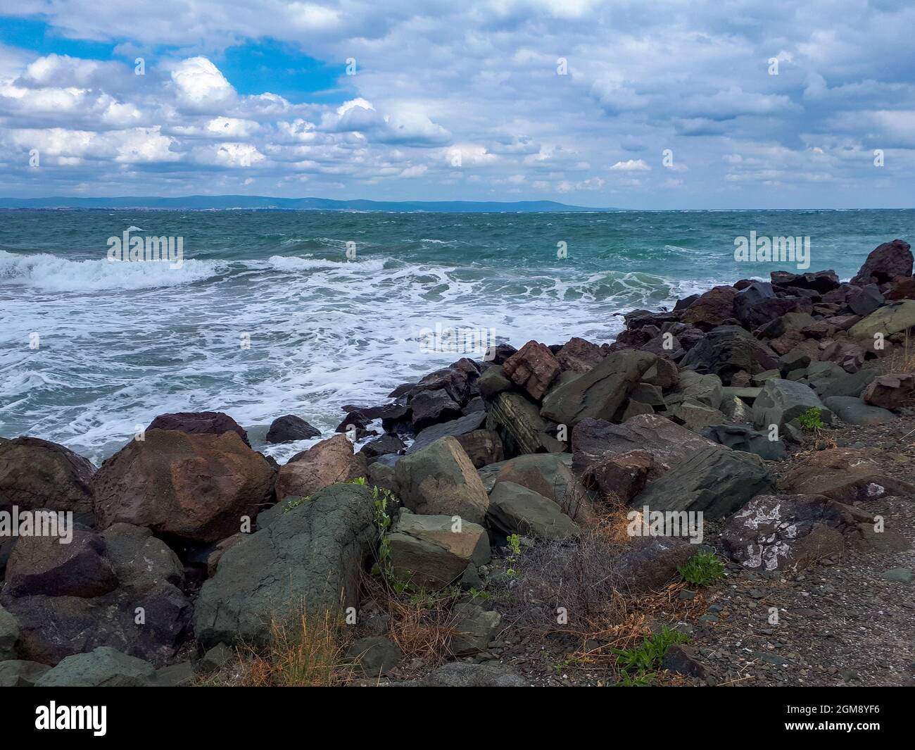 Vista panoramica della costa rocciosa con piante sul Mar Nero contro il cielo nuvoloso in estate a Pomorie, Burgas Bay, Bulgaria. Foto Stock