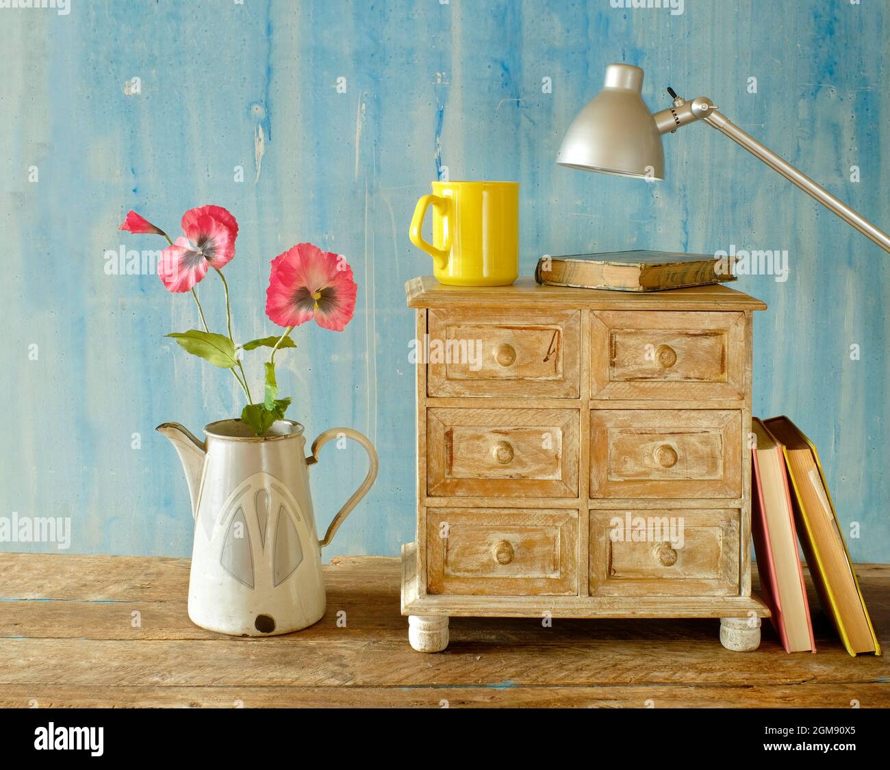 elegante soggiorno dal design elegante. Vista di interni in stile moderno con libri e cassettiera, lettura casalinga e concetto di minimalismo Foto Stock