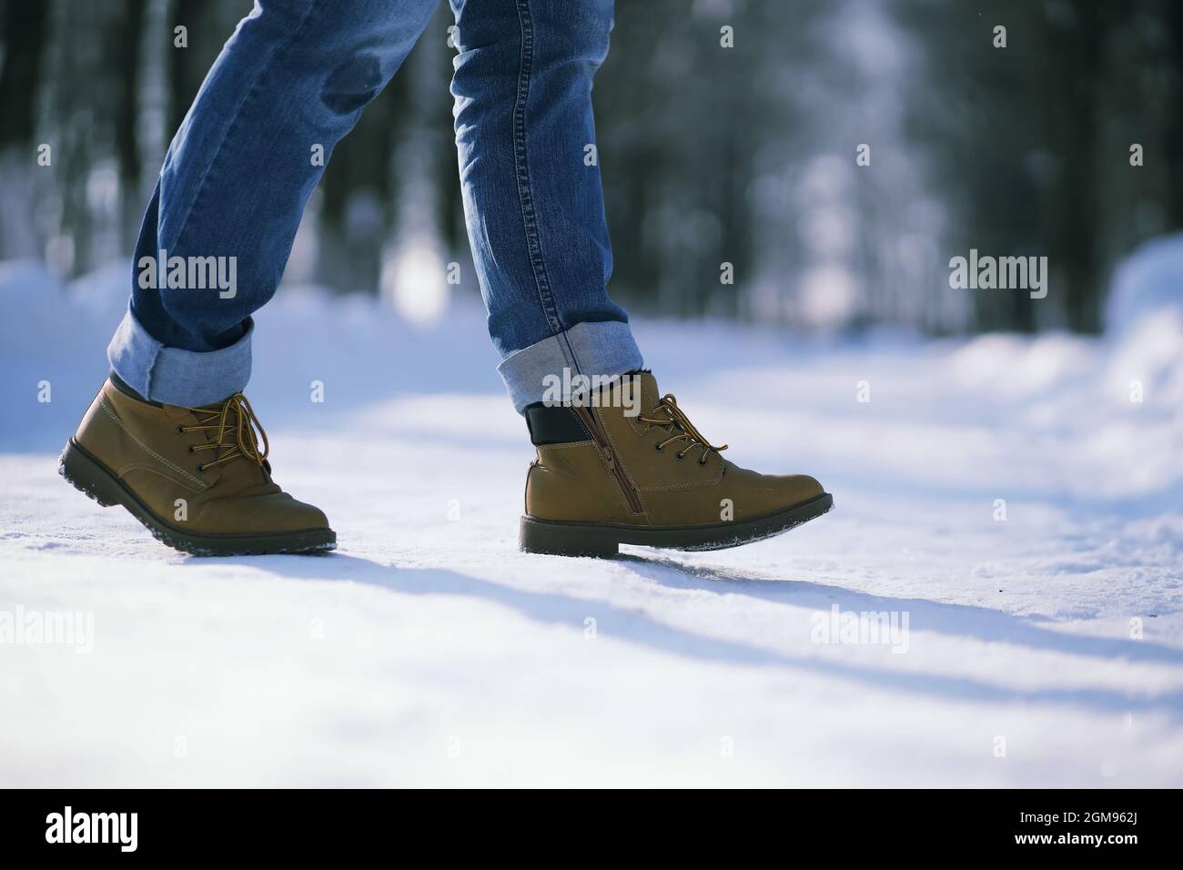 Passi lungo il sentiero innevato. Un uomo cammina nel parco in inverno. Foto Stock