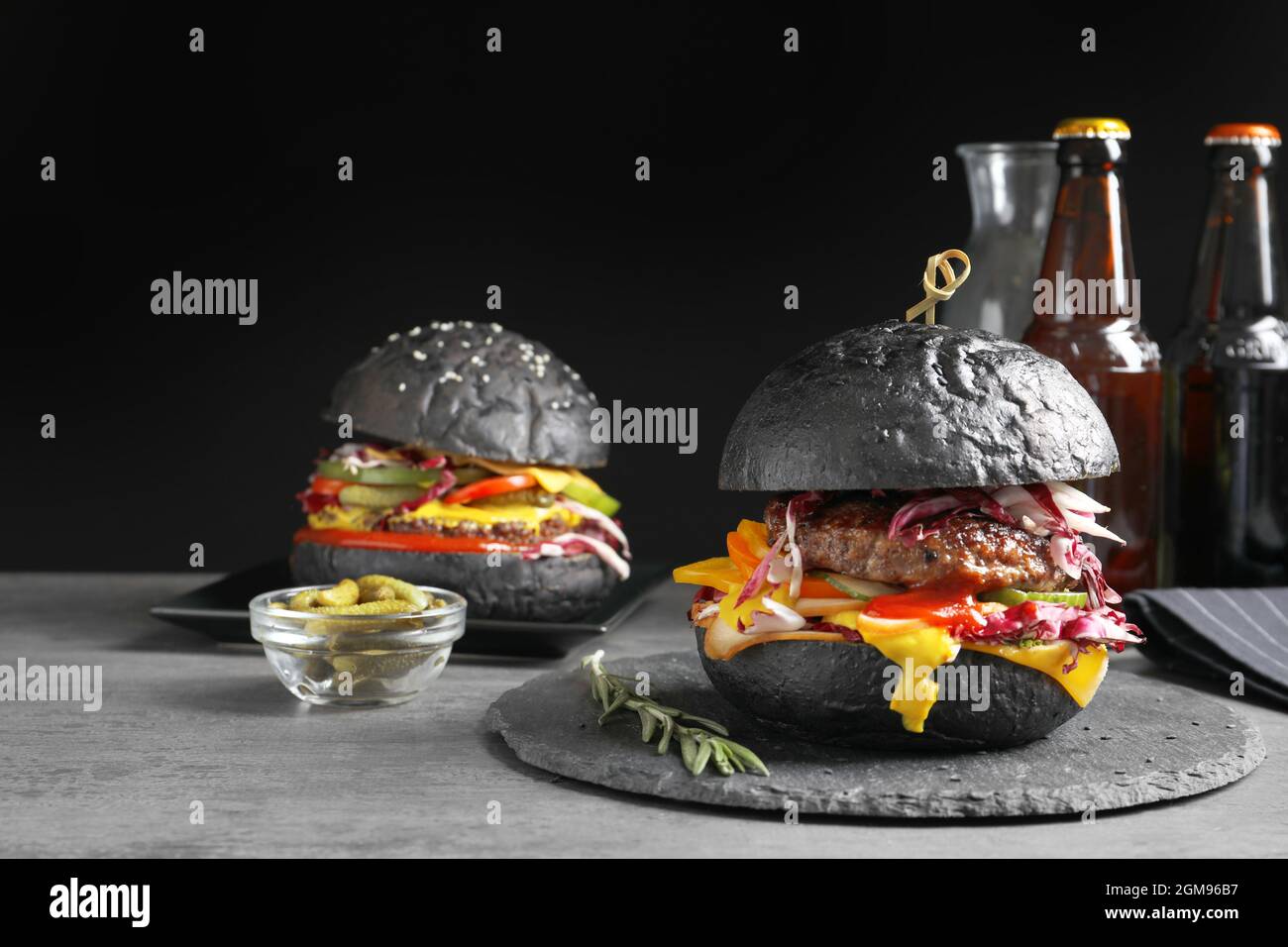 Piastra di ardesia con gustosi hamburger di nero sul tavolo Foto stock -  Alamy