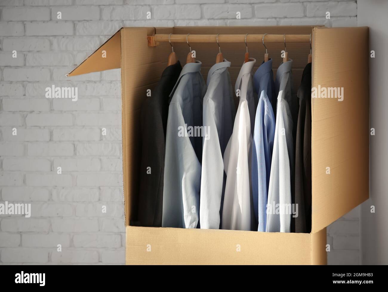 Cabina armadio con vestiti vicino a un muro di mattoni Foto stock - Alamy