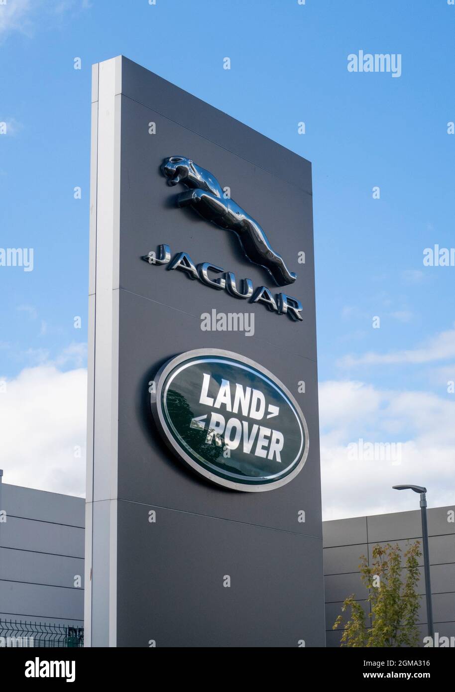 Logo e cartello Jaguar Land Rover all'esterno dello showroom del concessionario, Exeter Foto Stock