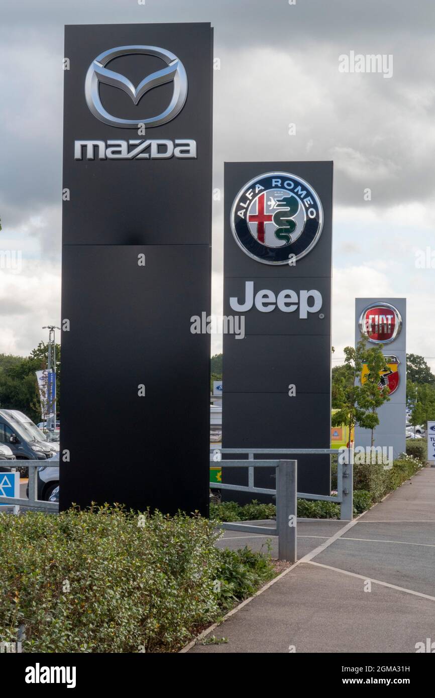 Fila di concessionari di automobili a Exeter - Mazda, Jeep, Alfa Romeo e Fiat auto logo e firmare fuori dal concessionario di automobili showroom, Exeter Foto Stock