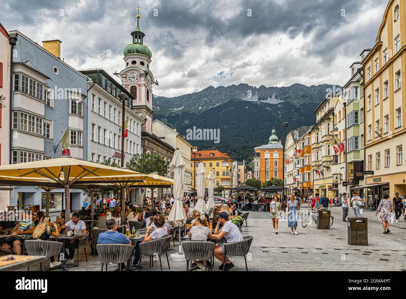 I turisti e la gente del posto si rilassano durante la giornata estiva chiacchierando e passeggiando su Maria-Theresien-Straße. Innsbruck, Tirolo, Austria, Europa Foto Stock