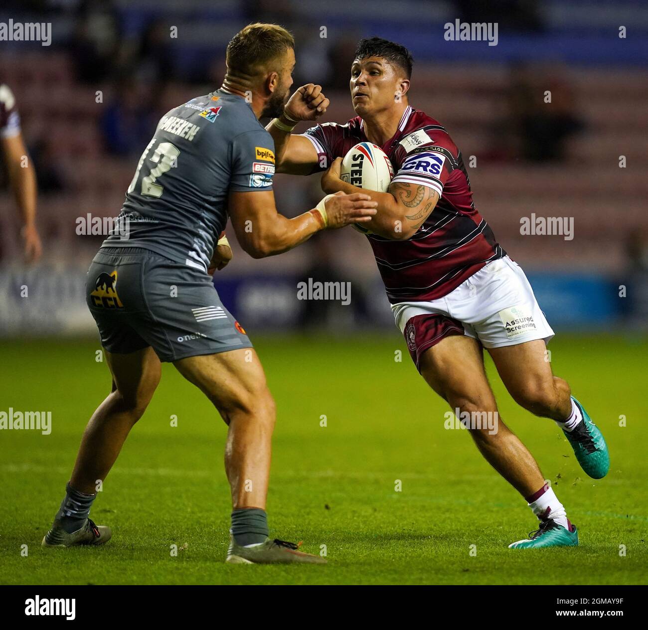 Mitch Clark (a destra) di Wigan Warriors corre con la palla verso Mike McMeeken dei Dragoni catalani durante la partita della Betfred Super League al DW Stadium di Wigan. Data foto: Venerdì 17 settembre 2021. Vedi la storia di PA RUGBYL Wigan. Il credito fotografico dovrebbe essere: Martin Rickett/PA filo. RESTRIZIONI: L'uso è soggetto a restrizioni. Solo per uso editoriale, nessun uso commerciale senza previo consenso da parte del titolare dei diritti. Foto Stock