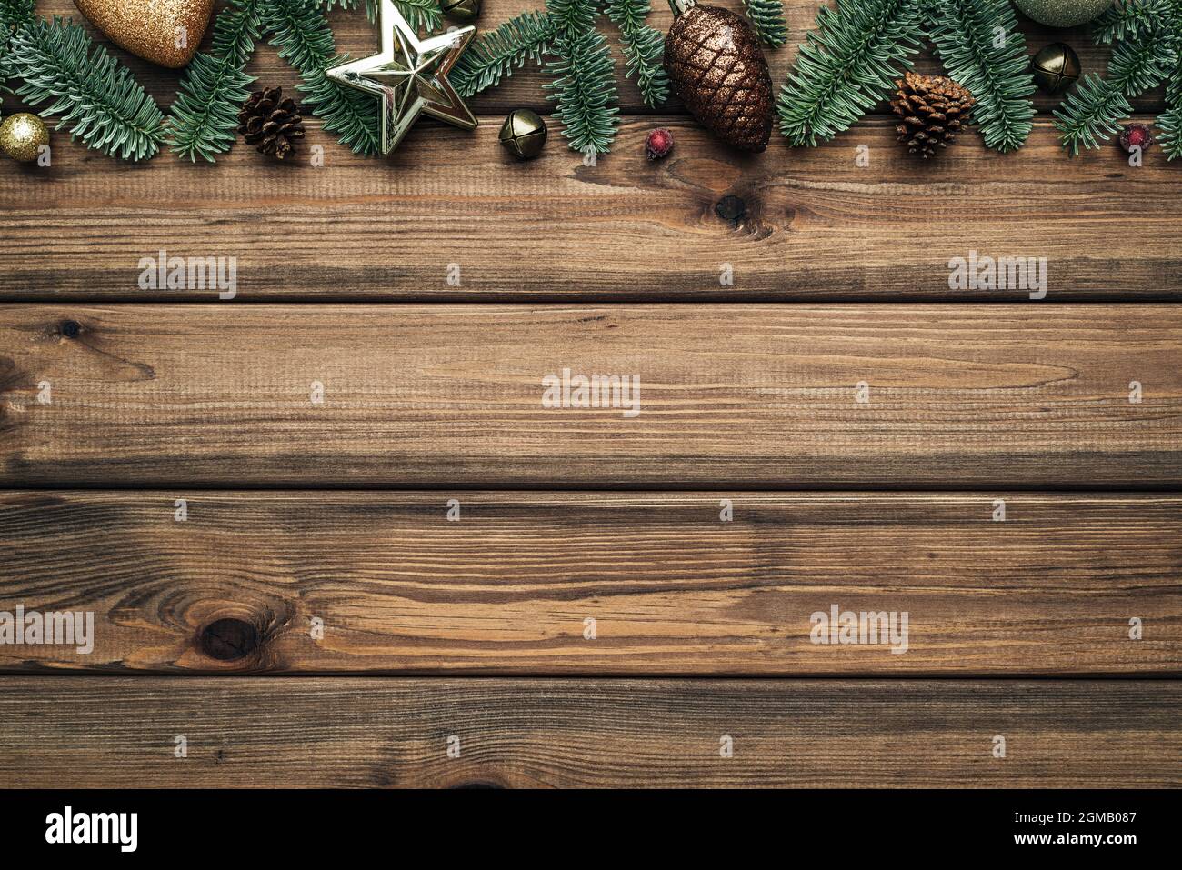 Vintage sfondo natalizio con rami di abete bordo su tavole di legno marrone. Disposizione piatta, vista dall'alto e spazio di copia per il testo Foto Stock