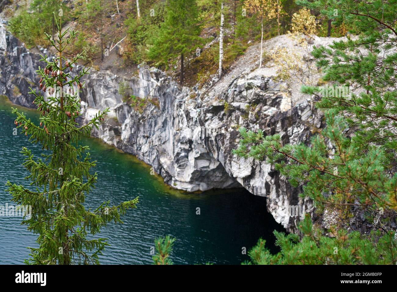 Un'ex cava di marmo nel Ruskeala Mountain Park piena di acque sotterranee e circondata da una foresta autunnale Foto Stock