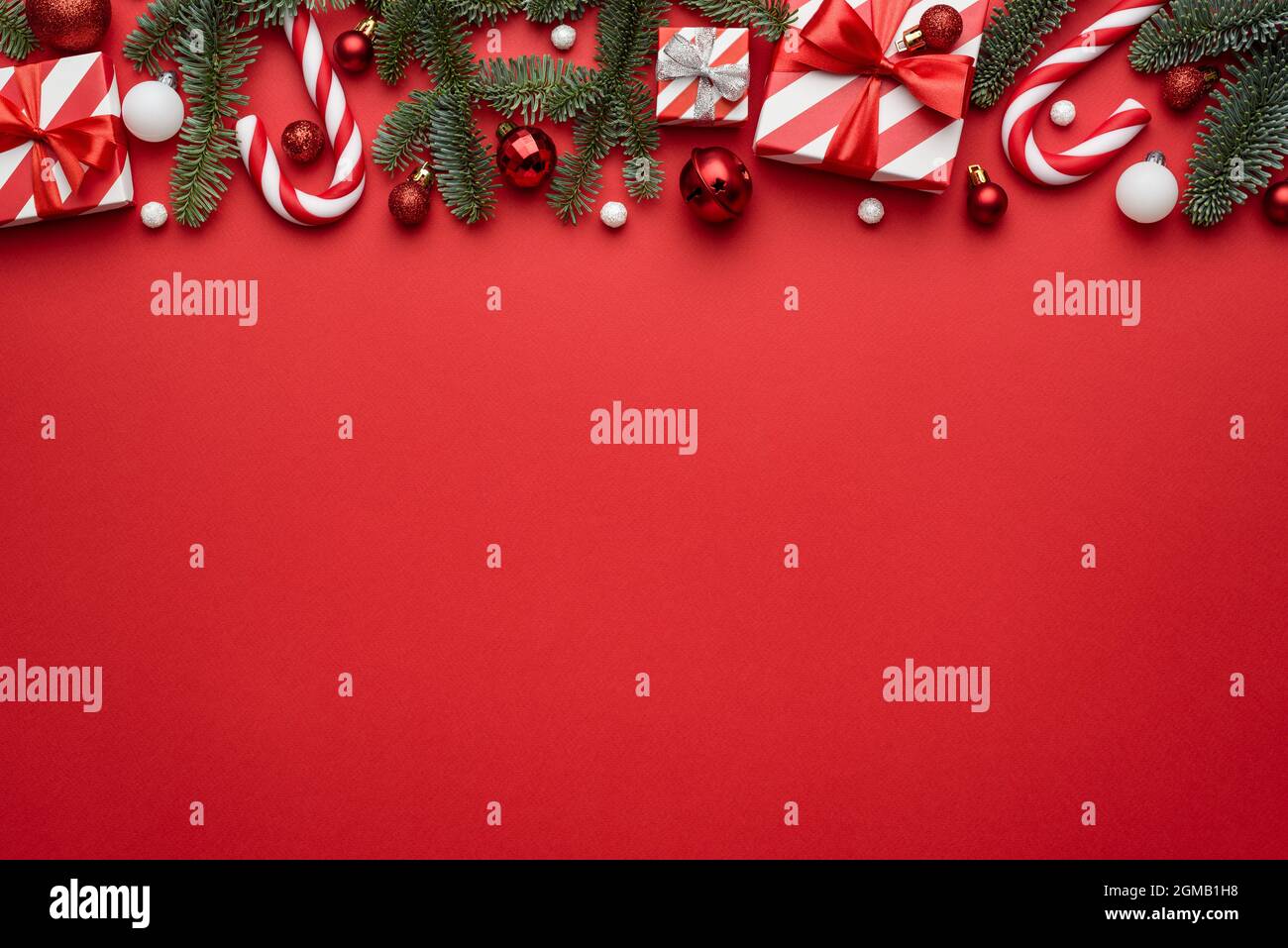 Sfondo rosso di Natale con bordo decorato con regali di festa e canne caramelle Foto Stock