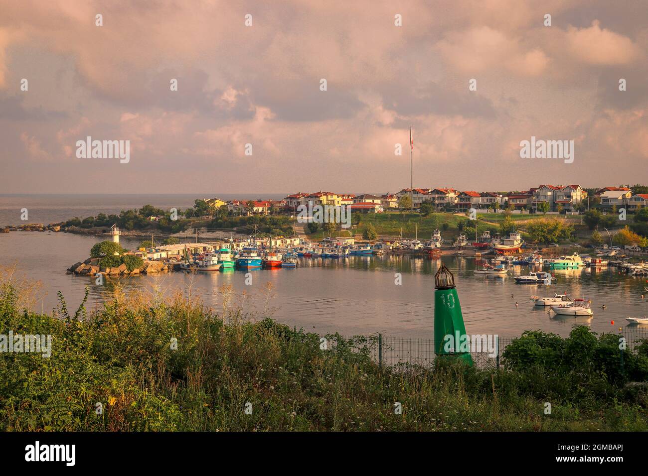 Mentre l'inverno tramanda la sua magia, il porto di pescatori si anima con una danza di nuvole di tempeste, erba secca e barche robuste. Una sinfonia marittima dove il ru Foto Stock