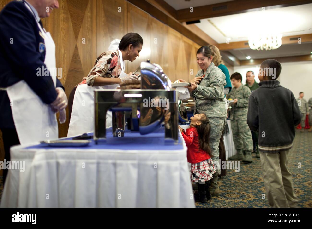 First Lady Michelle Obama si appoggia sui vassoi per parlare con una bambina come lei aiuta a servire il cibo per gli aerei e le donne degli Stati Uniti e le loro famiglie alla base aerea di Ramstein, in Germania, 11 novembre 2010. (Foto ufficiale della Casa Bianca di Chuck Kennedy) questa fotografia ufficiale della Casa Bianca è resa disponibile solo per la pubblicazione da parte delle organizzazioni di notizie e/o per uso personale la stampa dal soggetto(i) della fotografia. La fotografia non può essere manipolata in alcun modo e non può essere utilizzata in materiali commerciali o politici, pubblicità, e-mail, prodotti, promozioni che in alcun modo suggeriscono app Foto Stock