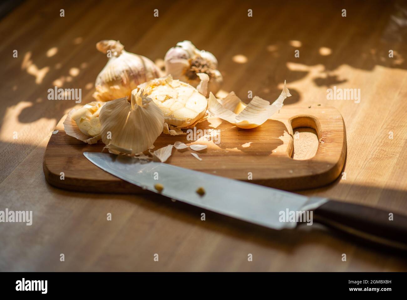 Colpo macro di mezzo bulbo d'aglio sul tagliere Foto Stock