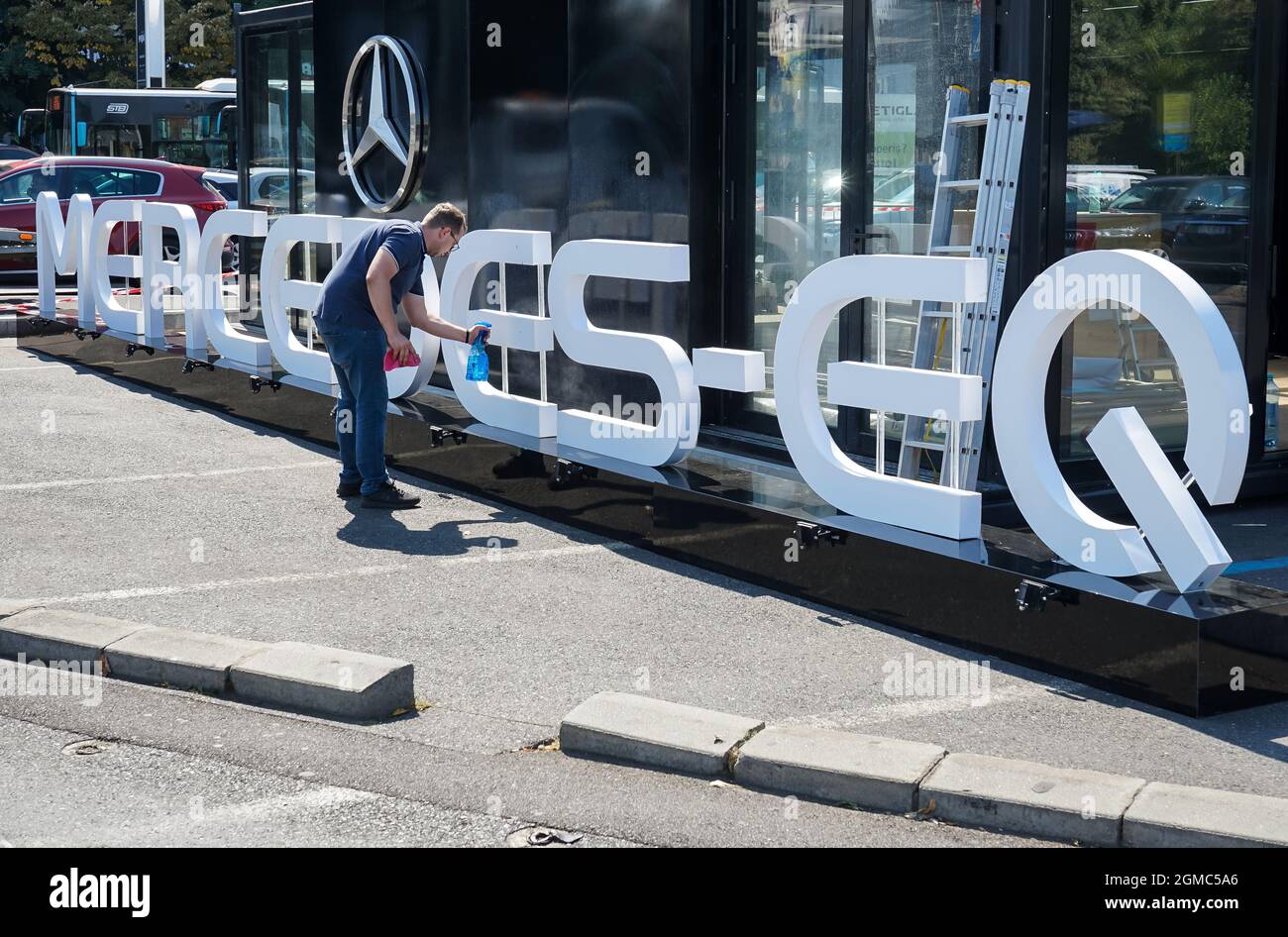Bucarest, Romania - 15 settembre 2021: Un dipendente che pulisce la pubblicità per il nuovo Pop-Up Store Mercedes-EQ che sarà aperto in Piazza Victoriei Foto Stock