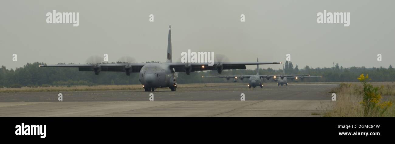 Due aerei C-130J Super Hercules della base aerea di Ramstein, Germania, e una forza aerea polacca C-130E Hercules si preparano per il decollo in rapida successione da un campo aereo abbandonato vicino Biala Podlaska, Polonia, durante la rotazione di distacco dell'aviazione 21.4, settembre 16, 2021. L'esercizio del concetto Agile Combat Employment di operazioni come questa mira a garantire che le forze aeree statunitensi Europa – forze aeree le forze africane siano pronte per potenziali minacce e contingenze, consentendo alle forze di disperdere rapidamente e continuare a fornire energia aerea da luoghi con livelli di capacità variabili e supporto. Foto Stock