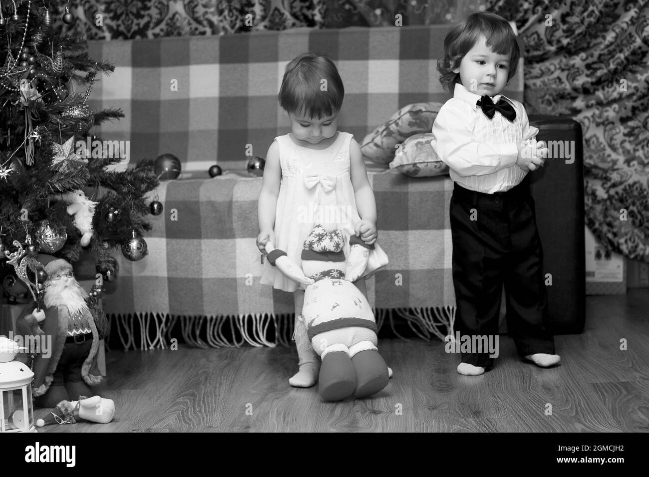 I bambini piccoli nei pressi di un albero di Natale prima delle vacanze Foto Stock