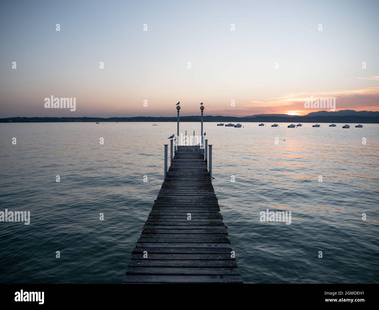 Molo del Lago di Garda o molo al tramonto in serata sulla penisola di Sirmione Foto Stock