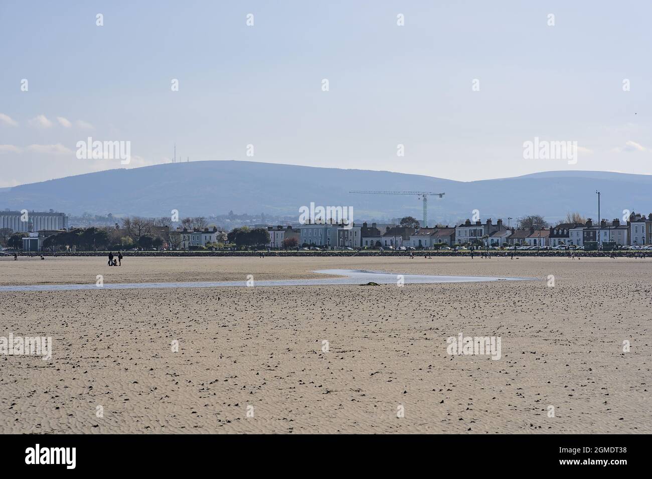 Bella vista luminosa su South Dublin e le montagne viste da Sandymount Beach, Dublino, Irlanda durante la marea più bassa. Persone a piedi. Spazi aperti Foto Stock