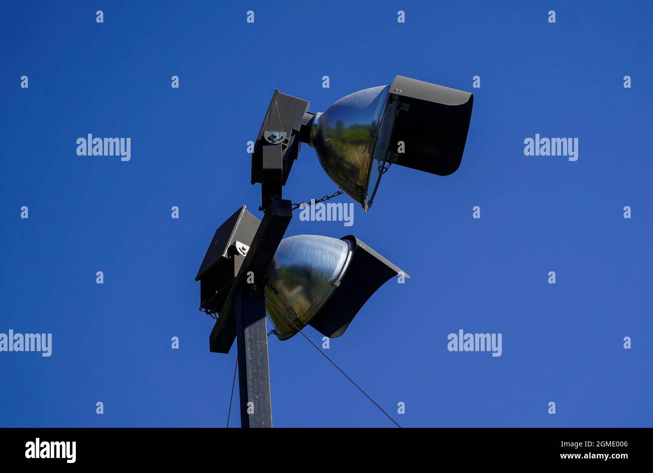 Primo piano di proiettori stradali su un palo di metallo isolato su sfondo blu Foto Stock