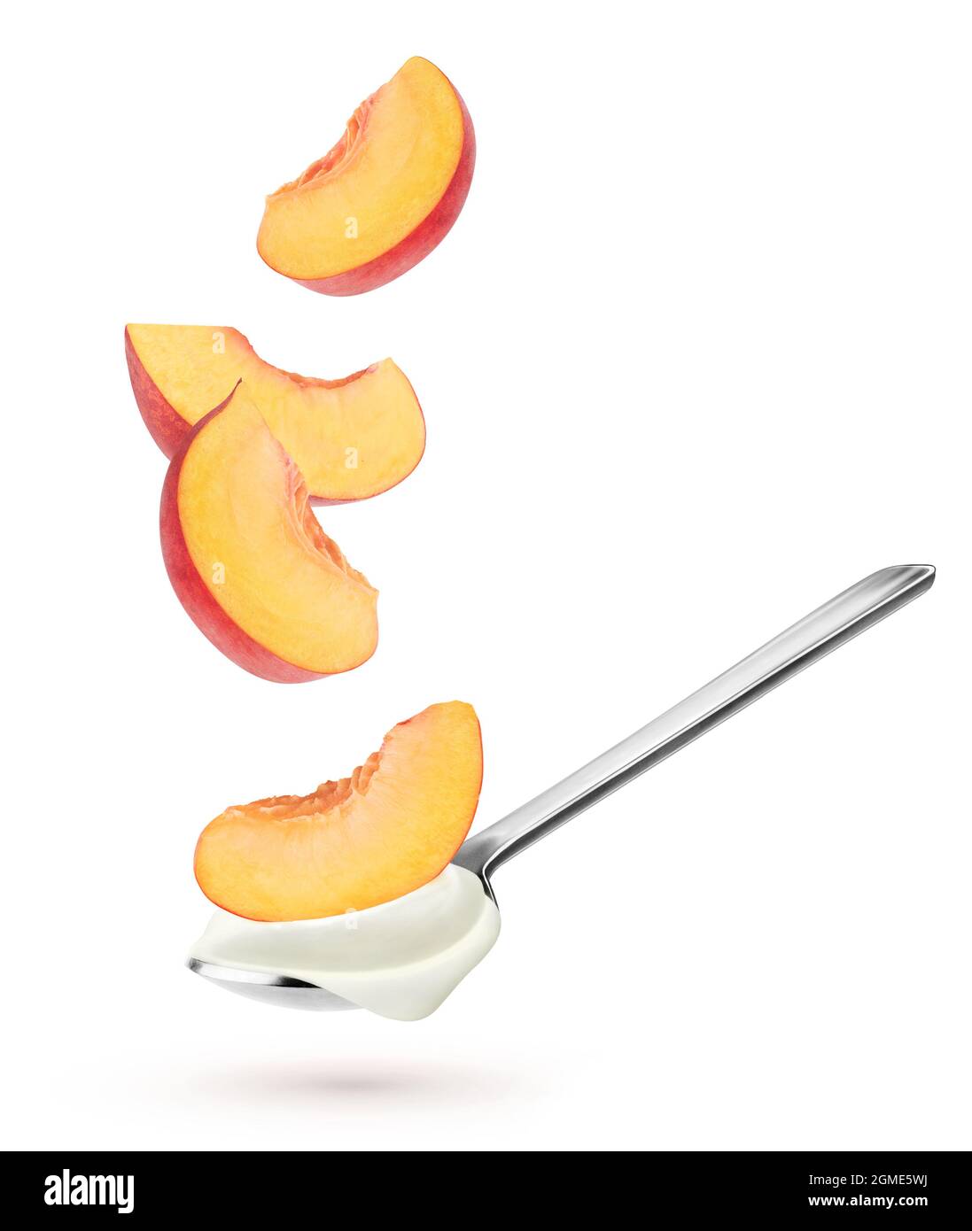 Yogurt isolato con frutta. Cucchiaio con yogurt naturale e fettine di pesca che cadono isolate su sfondo bianco Foto Stock