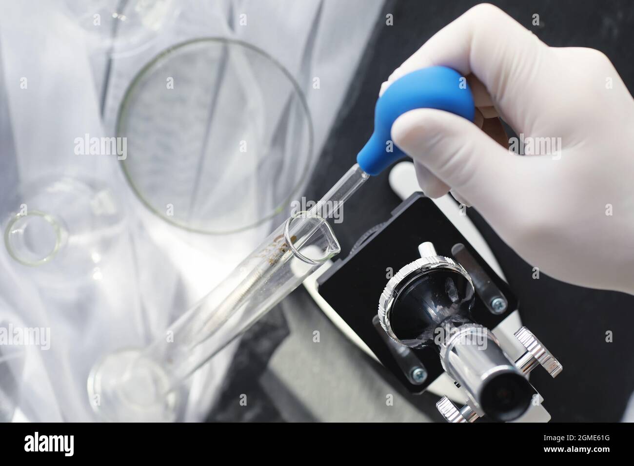 Ricerca di laboratorio. Analisi dei farmaci. Esperimenti chimici in laboratorio. Microscopio varie provette e becher sul tavolo presso il medico ufficiale. Foto Stock