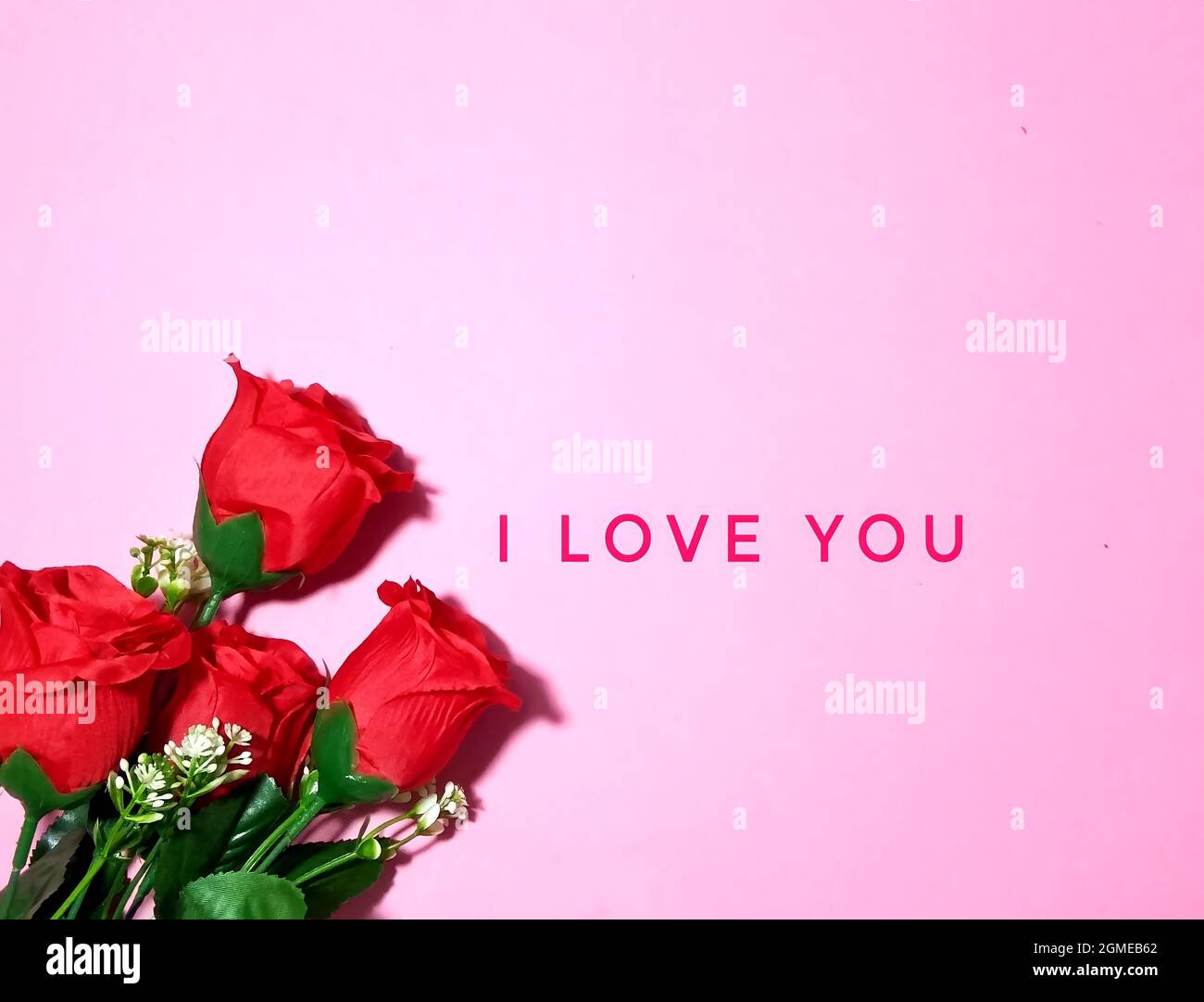 San Valentino, amore e concetto romantico. Bouquet di rose e TI AMO testo su sfondo rosa. Foto Stock