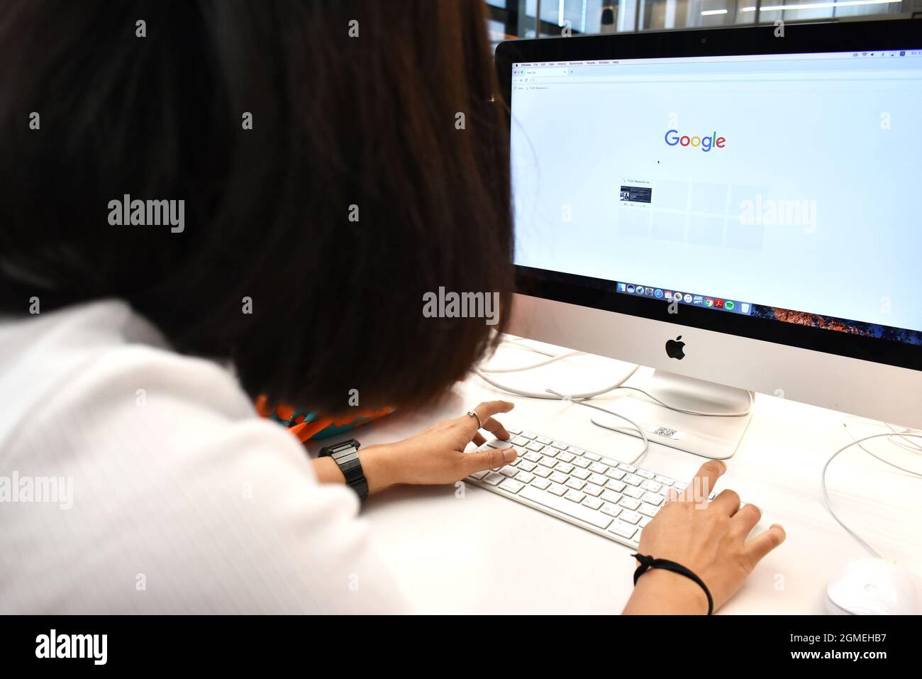 L'utente sta digitando una parola chiave nella barra di ricerca di Google sul browser del computer presso il Centro di Design creativo della Thailandia (TCDC), Bangkok Thailandia Foto Stock