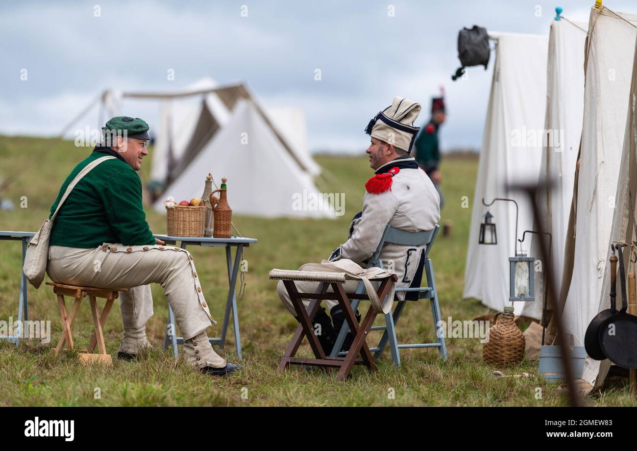 Nahrendorf, Germania. 18 settembre 2021. Gli artisti vestiti da soldati si sedettero insieme nel campo. La battaglia dei Göhrde contro le truppe di Napoleone ebbe luogo il 16 settembre 1813. Credit: Mars/dpa/Alamy Live News Foto Stock